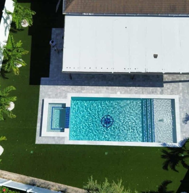 Aerial view of a backyard with a rectangular swimming pool and surrounding garden.